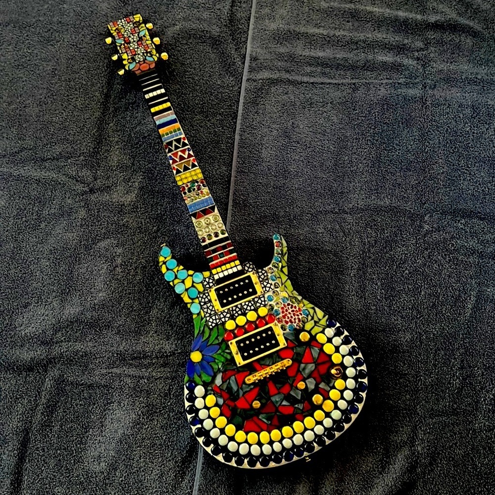 Les Paul guitar with decorative mosaic artwork.